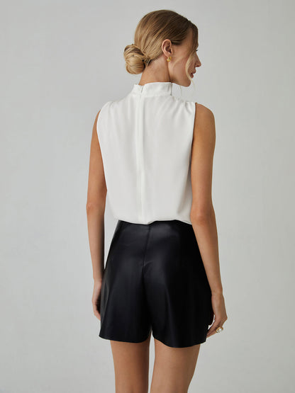 Blusa sin mangas, con cuello alto y pliegues