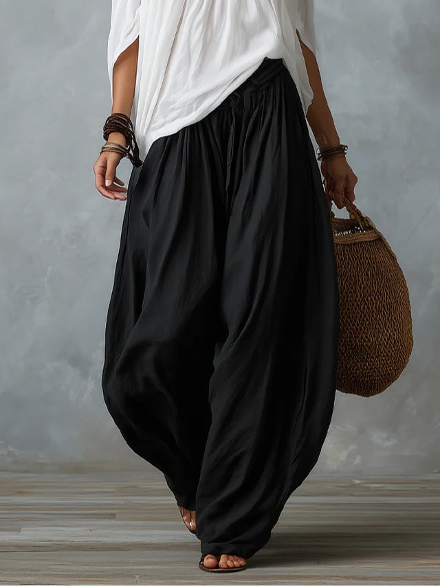Conjunto de top blanco con hombros descubiertos y pantalón de pierna ancha.