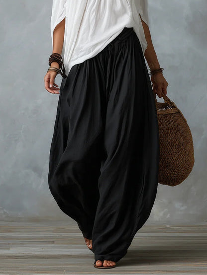 Conjunto de top blanco con hombros descubiertos y pantalón de pierna ancha.