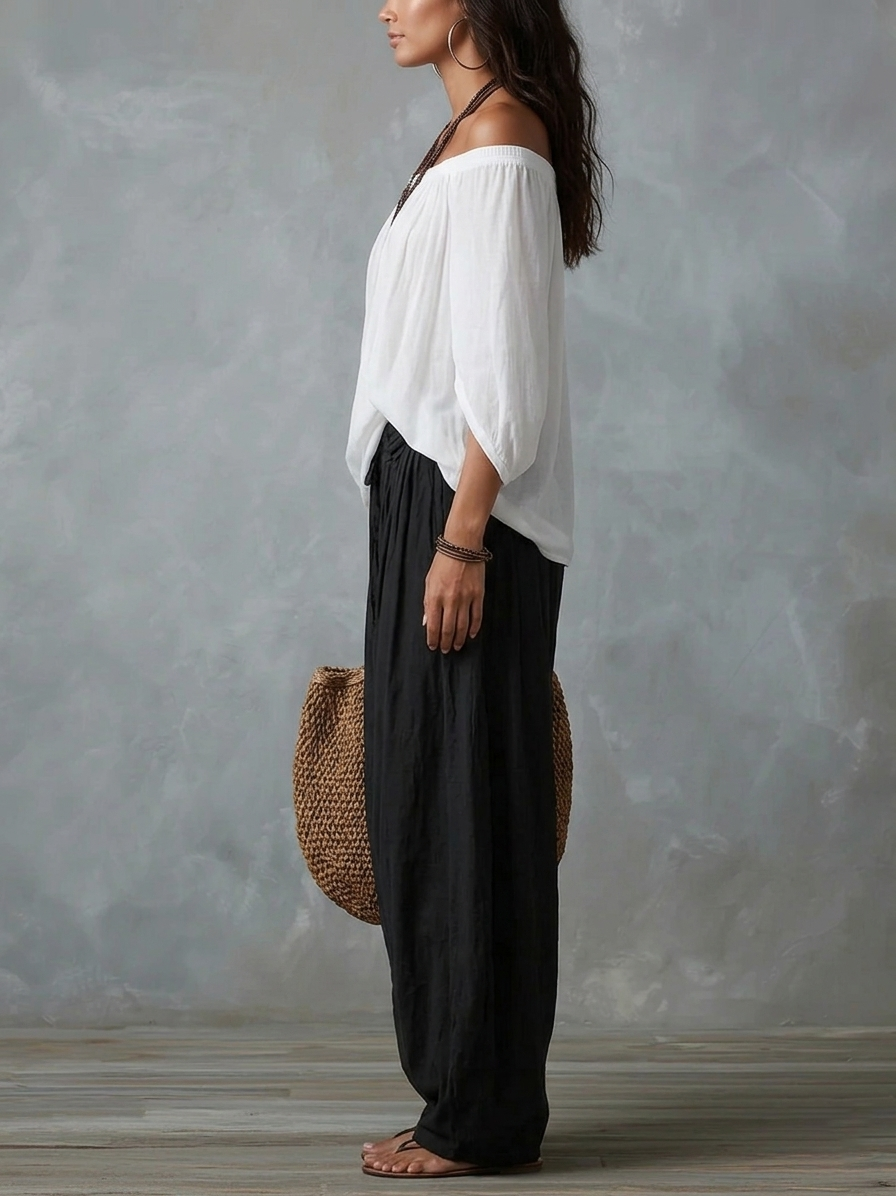 Conjunto de top blanco con hombros descubiertos y pantalón de pierna ancha.