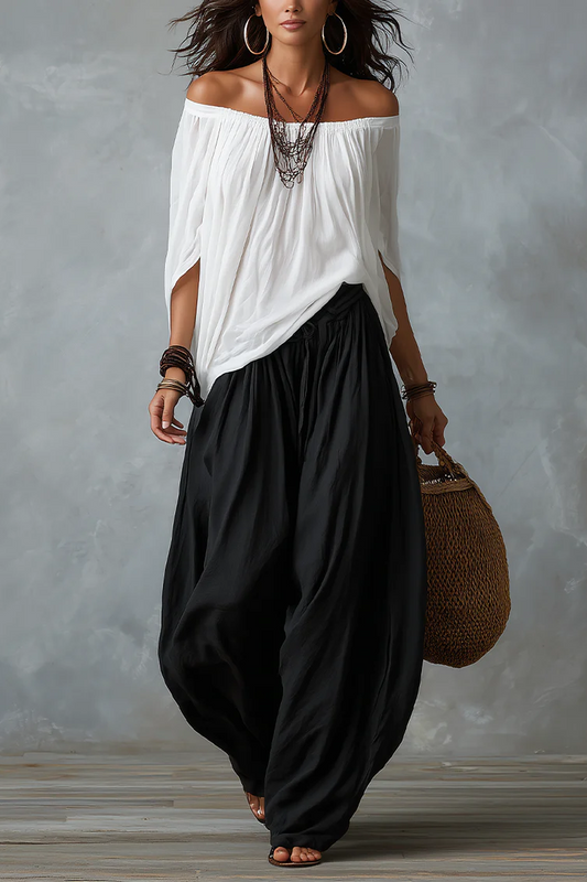 Conjunto de top blanco con hombros descubiertos y pantalón de pierna ancha.